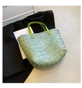 Green woven straw tote bag for women, stylish shoulder handbag with leather handles and rivets.