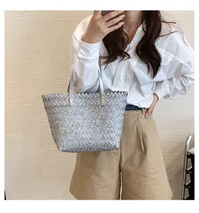 Stylish woven straw tote bag for women, elegant grey shoulder handbag with leather handles.