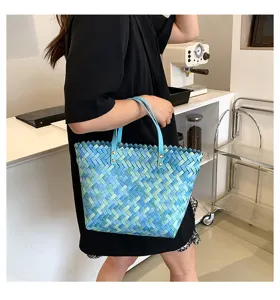 Blue woven shopper handbag for women, stylish gradient straw tote bag with double handles.