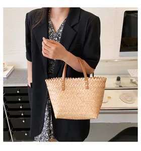 Stylish woven straw handbag with leather handles for women, perfect for spring and summer.