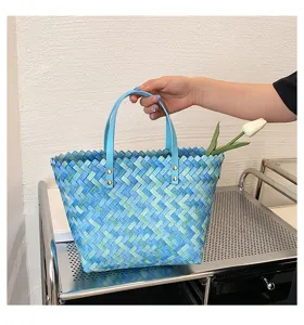 Blue woven tote bag detail showing intricate braided texture and sturdy metal-riveted handles.