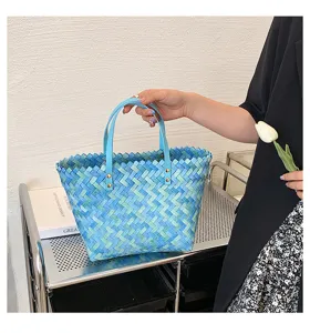 Chic blue woven tote bag with dual handles and metal rivets, perfect for spring and summer.