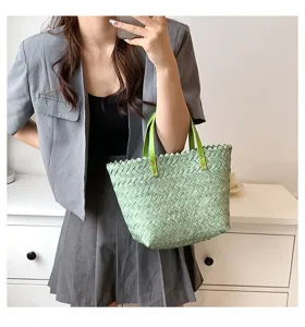 Detail view of a stylish green woven straw tote handbag, perfect for casual spring and summer.