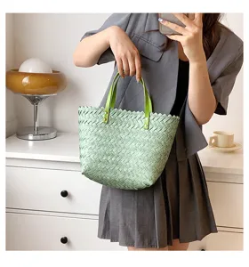 Light green woven straw handbag for women, stylish shoulder tote bag with green leather handles.