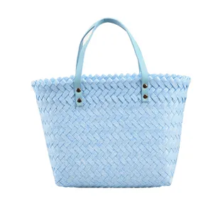 Detailed view of the light blue woven handbag, featuring delicate texture and sturdy handles.