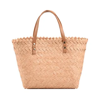 Woven straw tote bag with brown leather handles and metal rivets for casual daily use