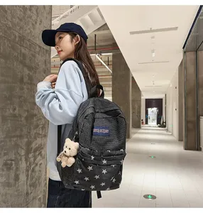 Detailed view of stylish denim and striped backpack with star pattern in corridor.