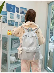 Mochila azul bonita con bordado de lazos, detalle de correas para estudiantes.
