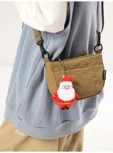 Detailansicht der khakifarbenen Nylon-Umhängetasche mit einem süßen Plüsch-Anhänger.