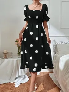 Detail view of the black polka dot dress highlighting the square neckline and ruffle hem.