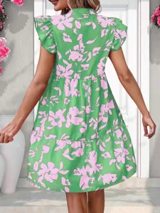 Detailed view of the green and pink floral ruffle sleeve tiered dress in a chic setting.
