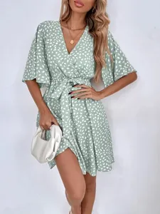 Green short sleeve V-neck wrap dress with cute white spot print and waist tie detail.