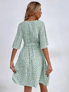 Detail view of the green dot V-neck short sleeve belted dress showcasing the print and waist.