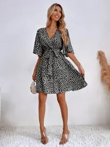 Detailed shot of the V-neck short sleeve polka dot midi dress with waist belt design.