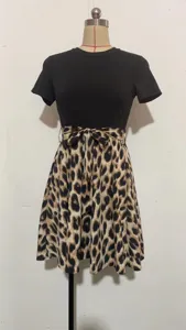 Détail du patchwork de la jupe imprimé léopard et du nœud de cravate à la taille sur la robe noire.