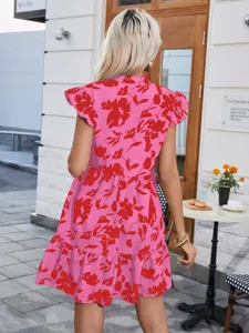 Detailed view of a pink floral print ruffle sleeve dress worn by a model outdoors.