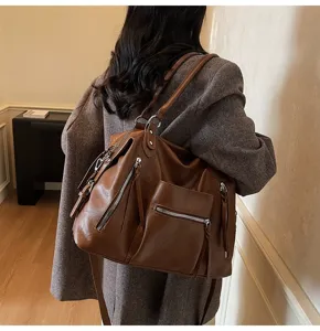 Gedetailleerd uitzicht op de grote vintage PU lederen tote bag met meerdere zakken.