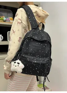 Vue détaillée du sac à dos noir motif étoiles avec charm peluche pour les étudiants.