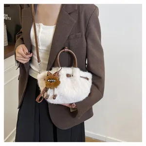 Fluffy plush bucket bag detail showing soft pleated design, leather handle and cute pendant.