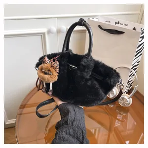 Detail shot of the black plush furry bucket bag, showing soft texture and cute pendant.