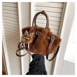 Brown plush bucket bag detail, stylish soft faux fur shoulder handbag with cute doll charm.
