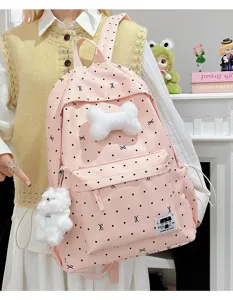 Süßer rosa Pünktchen-Schulranzen für Schüler mit Schleife und Plüschzubehör im Alltag.