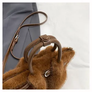Detailed close-up view of the soft brown plush bucket bag round handle and fuzzy texture.