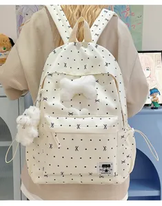 Detail des süßen gepunkteten Rucksacks mit weichem Plüsch-Knochenanhänger und Seitentaschen.