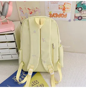 Lindo mochila escolar amarilla de lona con bordado de lazos dulces para estudiantes de moda.