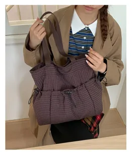 Detailansicht der braunen Karotasche mit Textur, praktischen Taschen und Kapazität.
