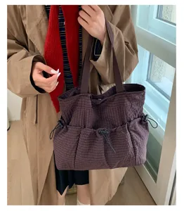 Detailansicht der karierten Shopper-Tasche mit Kordelzügen, stilvolle Umhängetasche für Damen.