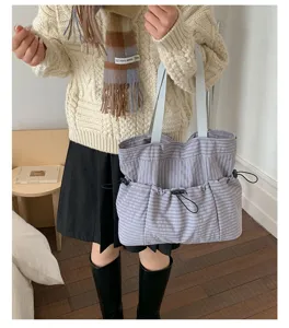Detailansicht der karierten Tasche mit großem Fassungsvermögen und praktischen Kordelzugtaschen.