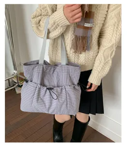 Detailaufnahme der grauen Karo-Tasche, große Tragetasche mit Vordertaschen und Kordel.