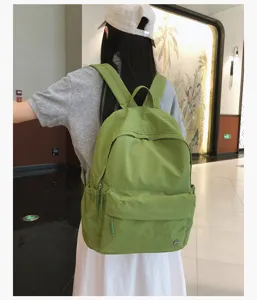 Vue détaillée du sac à dos en toile verte élégant porté par le modèle pour un usage quotidien.