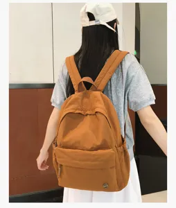 Vue détaillée du sac à dos de campus marron élégant porté par le modèle, look quotidien.