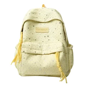 Gros plan détaillé du sac à dos étudiant jaune clair avec étoiles argentées scintillantes.