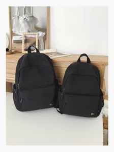 Vue détaillée du sac à dos noir au style collège classique, présenté en deux tailles.