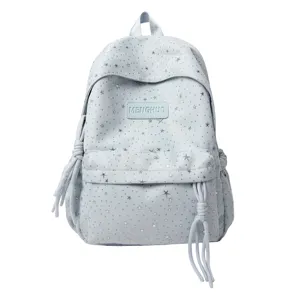 Gros plan sur la poche avant du sac à dos bleu clair étoilé et le logo de la marque MENGHUO.