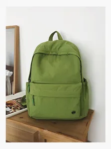Sac à dos décontracté vert en toile vue de détail, cartable léger style école pour usage quotidien.