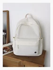 Sac à dos en toile style collège avec poche avant et poches latérales, minimaliste et décontracté.