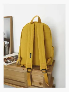 Détails du sac à dos jaune style campus en toile avec bretelles réglables et poches latérales.