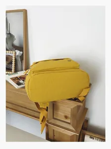 Sac à dos d'école en toile décontracté jaune vif, style collégien élégant pour usage quotidien.