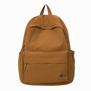 Vue détaillée de haute qualité du sac à dos en toile marron uni avec une poche zippée.