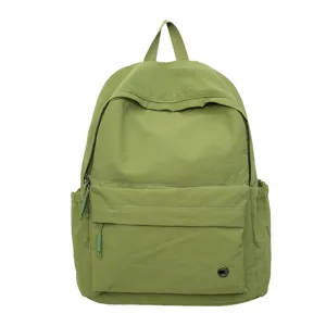 Vue détaillée de la poche avant du sac à dos vert pour les étudiants quotidiens.