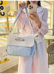 Detalle del bolso bandolera de cuadros con bonito bordado de gato y pequeño colgante de oso.