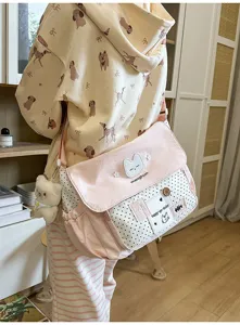 Cute pink polka dot canvas messenger bag for school girls, stylish crossbody bag.