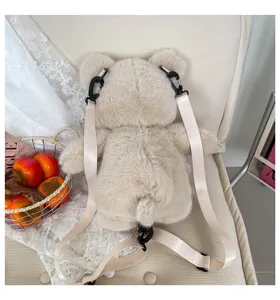Primo piano dettagliato del simpatico zainetto in peluche a forma di orso sulla poltrona.