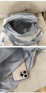 Detalle interior del bolso bandolera de lona, con compartimento principal y bolsillo con cremallera.