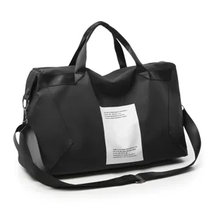 Detalle de bolsa de viaje negra, mostrando tela resistente y parche decorativo frontal.
