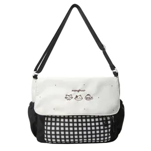Detalle del bolso bandolera de cuadros blancos y negros con bordado de gato.
